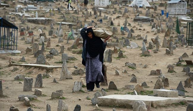 عبور زن افغان از مقبره اي نزديك شهر كابل