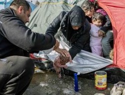 استحمام نوزاد بیست روزه با آب باران در مرز مقدونیه