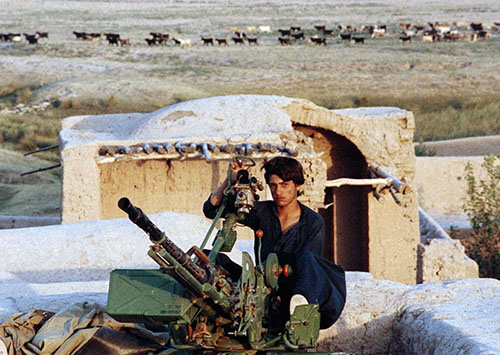 سرباز پیشین مجاهدین که اکنون به عضویت قوای دولتی درآمده در قلعه مخروبه‌ای در حومه هرات پشت تیرباز نشسته است. 30 اگست 1989